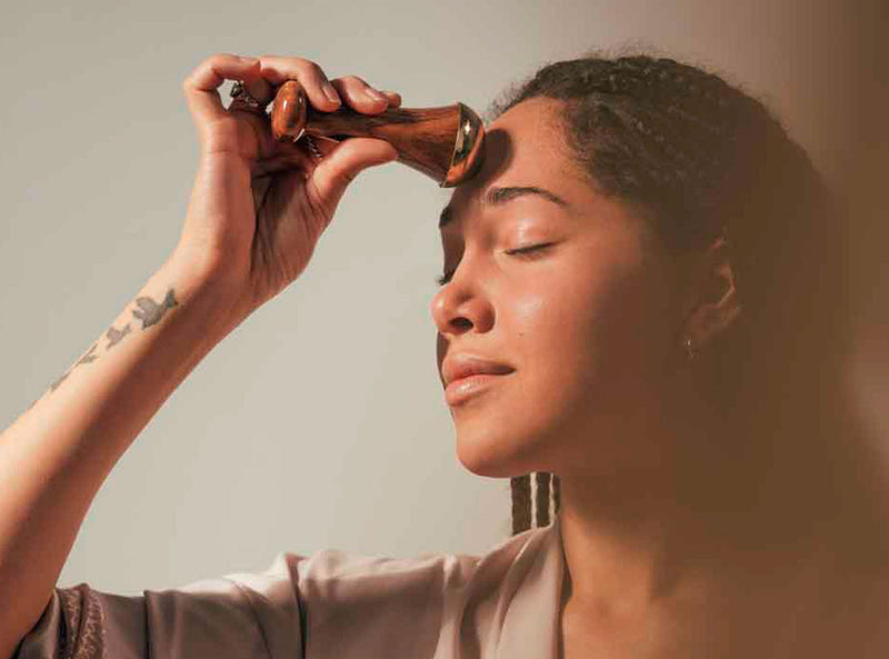 woman using kansa wand on forehead