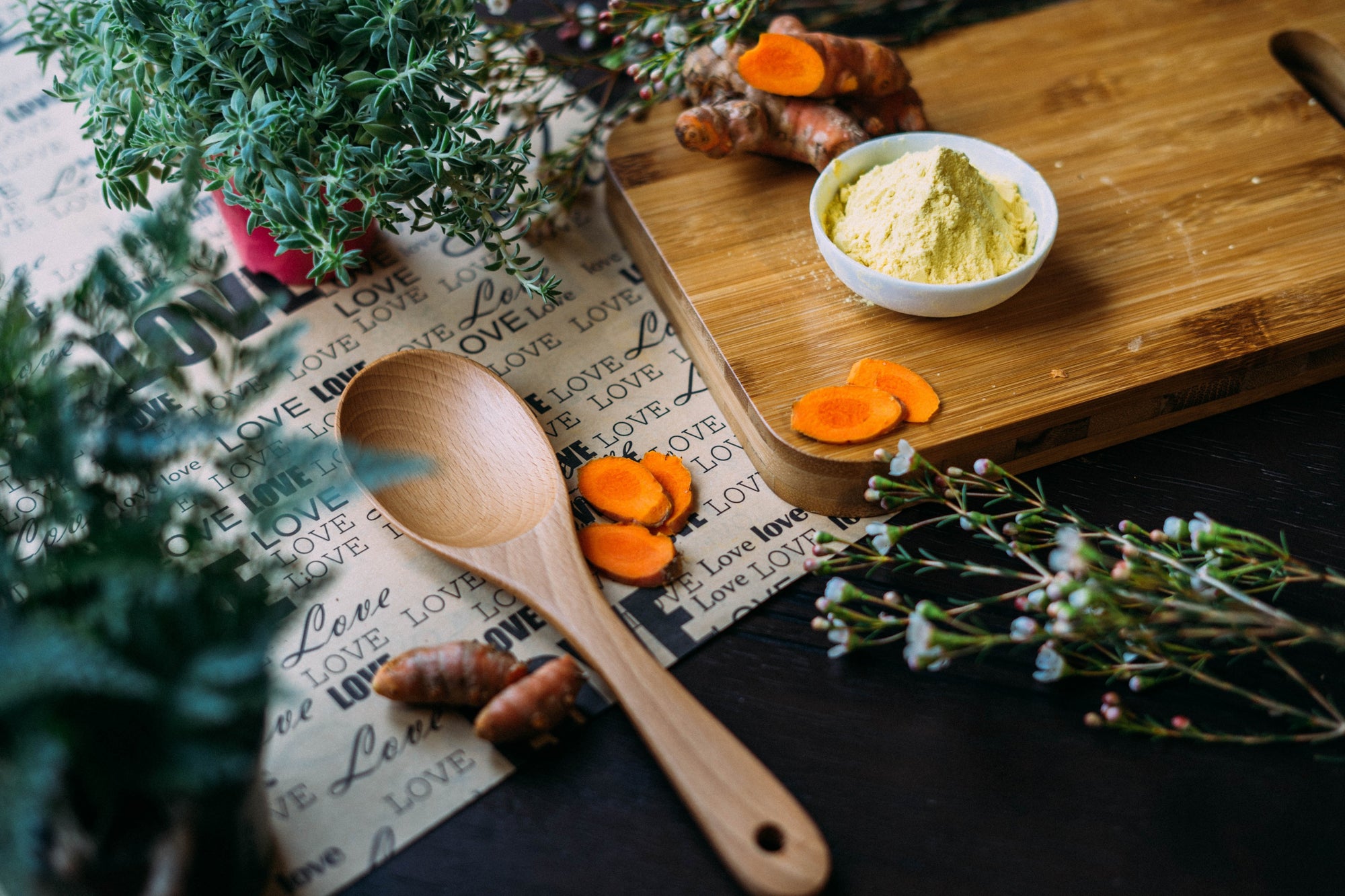 autumn kitchen preparation with wooden spoon carrots and herbs laid out on kitchen bench